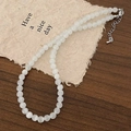 Detail of white translucent beaded necklace with silver lobster clasp on rustic paper - Cat's Eye Stone Beaded Necklace (Single Layer)