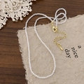 Detail of beaded necklace with gold lobster clasp and adjustable extension chain - Zircon White