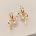 Dettaglio degli orecchini a fiocco dorato con ciondoli di perle su sfondo chiaro - Orecchini di Perle con Fiocco / Oro