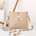 Detail of wave-quilted beige crossbody bag featuring cat pearl pendant and fabric strap - Khaki