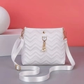 Detail of white quilted crossbody bag featuring a golden cat pearl tassel and strap - White