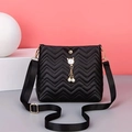 Detail of black wave quilted crossbody bag with pearl cat pendant and wide strap - Black