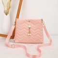 Detail of pink quilted crossbody bag featuring gold cat charm and pearl pendants - Pink
