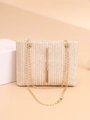 Detail of woven straw bag with chevron pattern and stylish gold tassel accent - Beige
