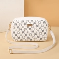 Detail view of heart print pattern on white quilted PU leather crossbody bag with gold hardware - White