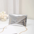 Silver crocodile texture envelope clutch bag with gold chain strap on white table - Silver
