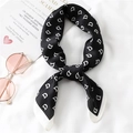 Close-up of black satin square scarf with white monogram D letters and contrast edge - Black