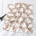Detailed shot of white silk-feel square scarf with gold chain print on fabric surface - Champagne Gold Ring Chain Style (FX-120)