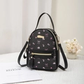 Mini black backpack for women featuring pink floral and bow prints with gold hardware - Black