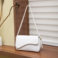 Bolso de hombro blanco minimalista en cuero con herrajes dorados en mesa madera - Blanco