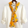 Dettaglio di una sciarpa in seta gialla a fiori annodata su un abito bianco - Giallo Brillante Fiore Contorno (LJ21-2)