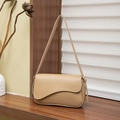 Bolso de hombro moderno de cuero beige con solapa ondulada sobre superficie de madera - Albaricoque