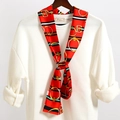 Dettaglio macro di un foulard in seta rossa con fibbia dorata e motivi a strisce - Riga Rosso Verde Fibbia Metallo (LJ21-27)