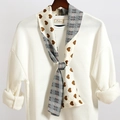 Vista dettagliata di una sciarpa sottile reversibile con cuori e motivi a quadretti - Reversibile Cuore Crema Plaid Grigio Nero (LJ21-31)
