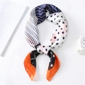 Close-up of geometric polka dot silk scarf with vibrant orange and navy stripe patterns - Orange Border