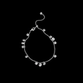 Dettaglio macro di una collana a sfere argentate con pendenti in zircone su sfondo nero - Bracciale in Zirconia a Goccia d'Argento