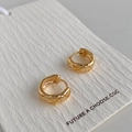 Detalle macro de pendientes de aro dorados con grabado acolchado matelasé pulido - Hebilla de Oreja con Patrón Acolchado Dorado