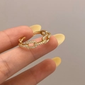 Detail of gold-plated chain-link adjustable ring with pavé-set white zircons on finger - Gold