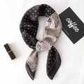 Elegant black and white paisley and polka dot square scarf tied on a knit background - Paisley Black