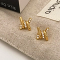 Close-up of gold twisted earrings with micro-pave white zircons on beige fabric - Gold Ring Zircon (A-926)