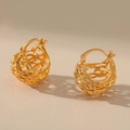Golden hollow woven nest earrings with elegant spherical design on warm beige background - Gold Hollow Spherical Bird's Nest Ear Buckle