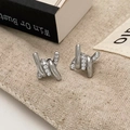 Detailed view of silver twisted knot stud earrings with pave zircon on beige canvas bag - Silver Ring Zircon (A-926)