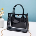 Transparente PVC-Handtasche mit schwarzem Rand und Kettenriemen neben weißen Blumen - Schwarz