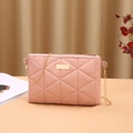 Borsa a tracolla rosa trapuntata con catena dorata e placca su sfondo dai toni caldi - Rosa