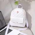 White quilted mini backpack for women featuring pink rose metal logo on grey sofa - White