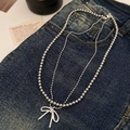 Double-layered gray beaded necklace featuring a sleek bow pendant on blue denim fabric - Double Layer Pearl Bowknot Necklace (Silver) / Silver