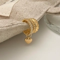 Detail of gold layered ear cuff with heart pendant on beige linen texture background - Gold Heart Pendant Ear Cuff