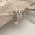 Detail of silver heart ear cuff with layered chain and crystal pavé on linen fabric - Silver Heart Pendant Ear Cuff