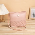 Pale pink quilted shoulder bag with gold butterfly accent and slim strap on wood - Pink