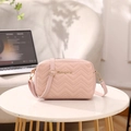 Chic pink crossbody bag featuring V-shaped chevron quilting and gold metal logo detail - Pink