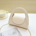 Mini sac à main beige texturé avec chaîne dorée présenté dans un décor élégant - Blanc