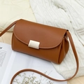 Piccola borsa a tracolla marrone in pelle martellata con fibbia dorata su maglione bianco - Marrone