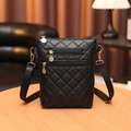 Quilted black crossbody phone bag with gold zippers on light wooden table - Black