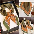 Detailansicht eines Seidenschals mit geometrischem Karomuster in einer eleganten Geschenkbox - 70*70cm / Olivgrün/Warmes Orange/Weiß Geometrisch