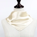 Detailed view of champagne satin square scarf draped gracefully on a boutique mannequin - Beige