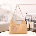 Bolso hobo acolchado beige con bolsillo delantero en contraste sobre mesa blanca - Caqui