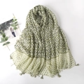 Detail of green printed scarf featuring geometric waves, heart patterns and fine tassels - Green