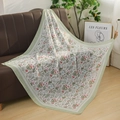 Close-up of premium floral cotton hijab with lace edge on a brown leather sofa - Dusty Green Butterfly & Floral Style (Style 8)