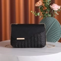 Bolso bandolera de tejido negro con cadena dorada sobre mesa de mármol blanco puro - Negro