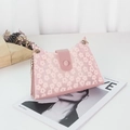 Sac bandoulière en dentelle rose avec broderie marguerite et chaîne dorée sur un magazine - Rose