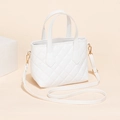 White quilted bucket bag with gold hardware and adjustable strap in a soft cream setting - White