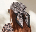70cm paisley print satin scarf in brown and purple, worn as a retro bohemian headscarf - Black