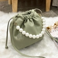 Sage green litchi texture bucket bag with pearl handle and drawstring detail - Green