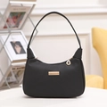 Elegante bolso de hombro en cuero negro con detalles dorados en un sofá amarillo - Negro