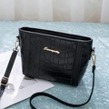 Nahaufnahme einer schwarzen Krokostil-Lederhandtasche mit goldenem Logo und Trägerdetails - Reines Schwarz