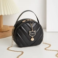 Black round quilted crossbody bag with golden cat charm and chain strap detail - Black